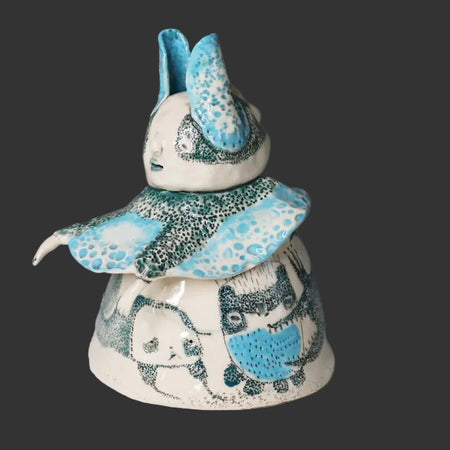 Ceramic figure with blue and white accents on a gray background