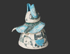 Ceramic figure with blue and white accents on a gray background