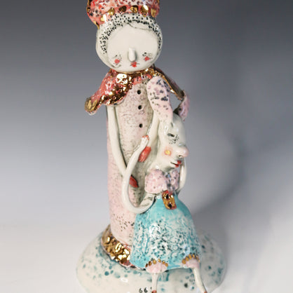 Decorative ceramic figure with a pastel color scheme on a gradient background