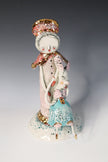 Decorative ceramic figure with a pastel color scheme on a gradient background